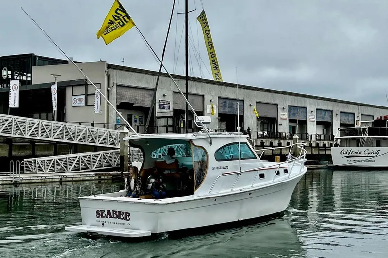 Slide: The Image of 1999 Mainship Pilot 30 boat named "Seabee" docked at a marina. - 7