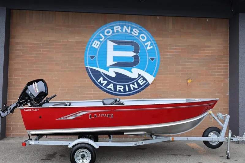 The Image of 2026 Lund 1400 Fury Tiller boat in red on a trailer at Bjornson Marine. - 1