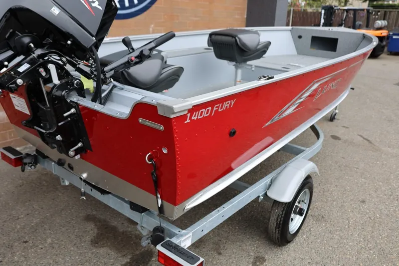 Slide: The Image of 2026 Lund 1400 Fury Tiller boat in red on a trailer, featuring a motor. - 11