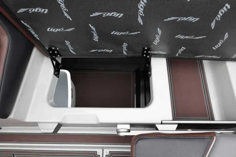 Slide: The Image of 2026 Tigé 22RZX boat storage compartment with open lid, showcasing interior design. - 49