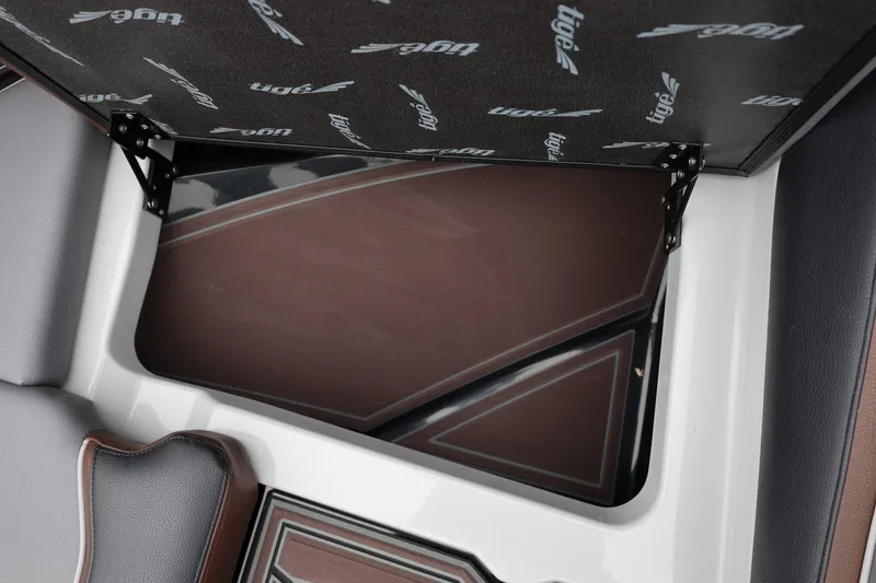 Slide: The Image of 2026 Tigé 22RZX boat storage compartment with open lid, showcasing interior design. - 58