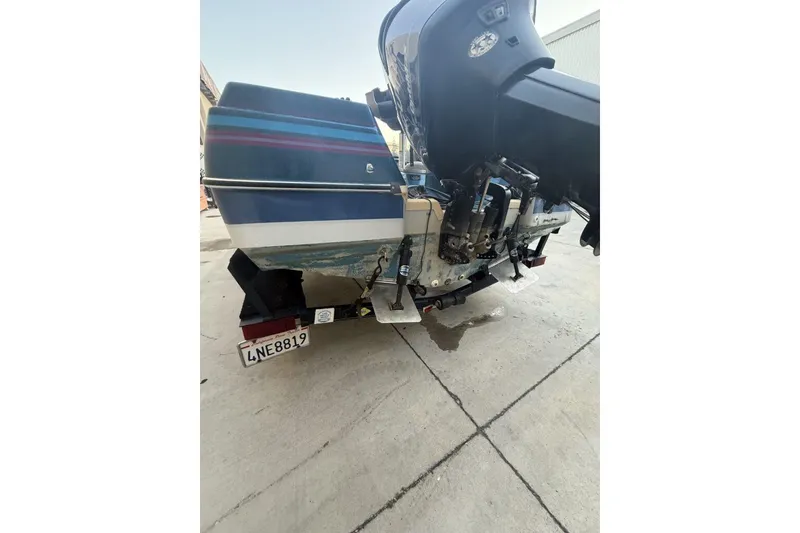 Slide: The Image of 1989 Bayliner 1800 Cobra boat rear view with motor, on trailer, license plate visible. - 18