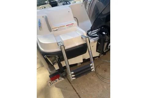 Slide: The Image of 2013 Bayliner 170 Bowrider boat with ladder and motor, parked on concrete. - 5