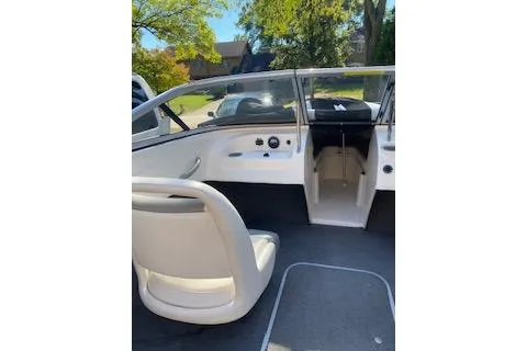 Slide: The Image of 2013 Bayliner 170 Bowrider interior with seating and dashboard, parked outdoors. - 8