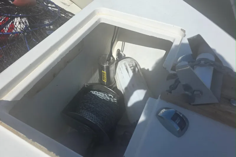 Slide: The Image of 2017 Cobia T-Top boat anchor compartment with winch and chain. - 10
