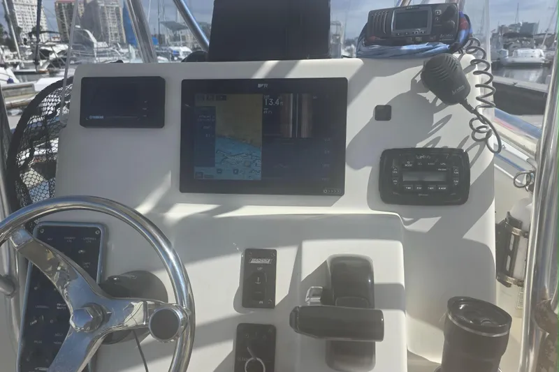 Slide: The Image of 2017 Cobia T-Top boat dashboard with navigation and control systems in a marina setting. - 3