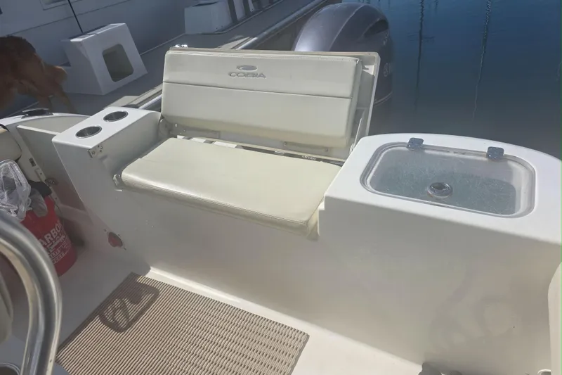 Slide: The Image of 2017 Cobia T-Top boat interior with seating, cup holders, and storage compartment. - 6