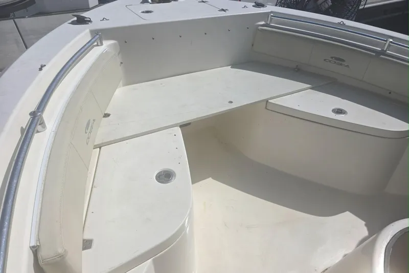 Slide: The Image of 2017 Cobia T-Top boat interior with white seating and storage compartments. - 8