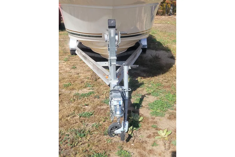 The Image of 2000 Sea Ray 260 Sundancer boat on trailer, parked on grassy area. - 0