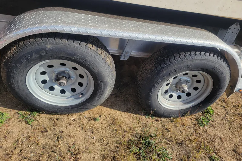 Slide: The Image of Trailer wheels for 2000 Sea Ray 260 Sundancer boat on sandy ground. - 18