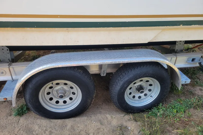 Slide: The Image of Trailer wheels for 2000 Sea Ray 260 Sundancer boat on sandy ground. - 20