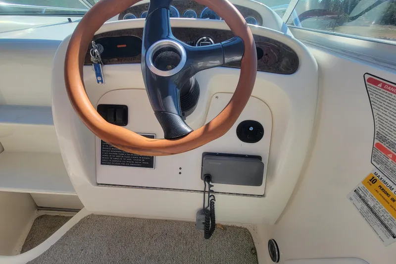Slide: The Image of Steering wheel of a 2000 Sea Ray 260 Sundancer boat, featuring a wooden grip. - 27