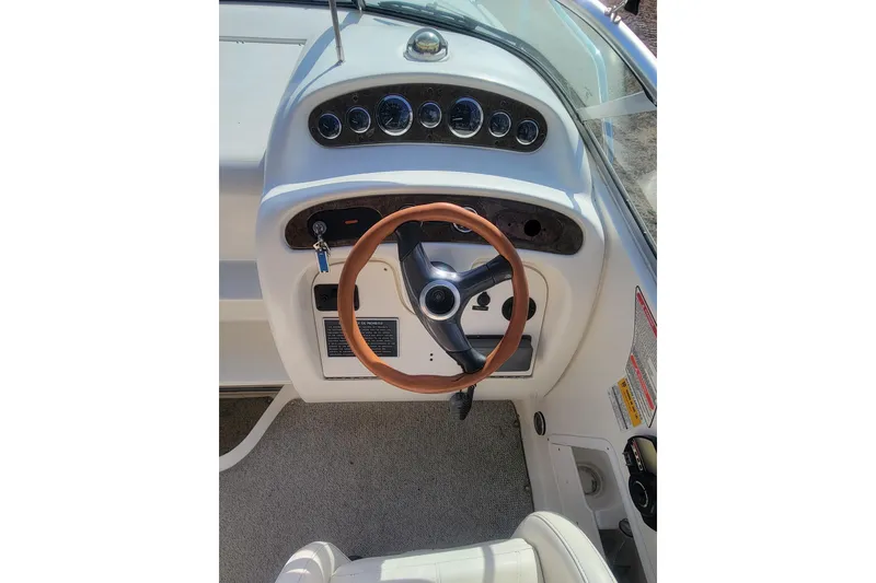 Slide: The Image of 2000 Sea Ray 260 Sundancer helm with gauges and brown steering wheel. - 6