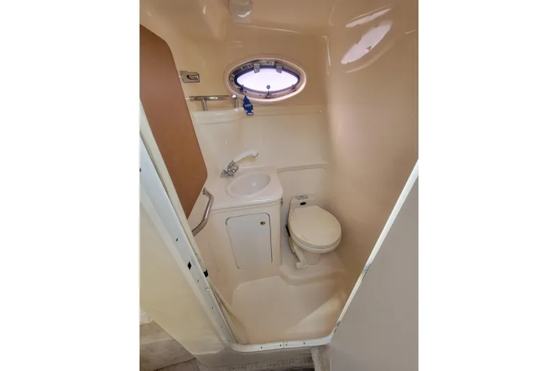 Slide: The Image of 2000 Sea Ray 260 Sundancer boat bathroom with sink, toilet, and porthole window. - 8