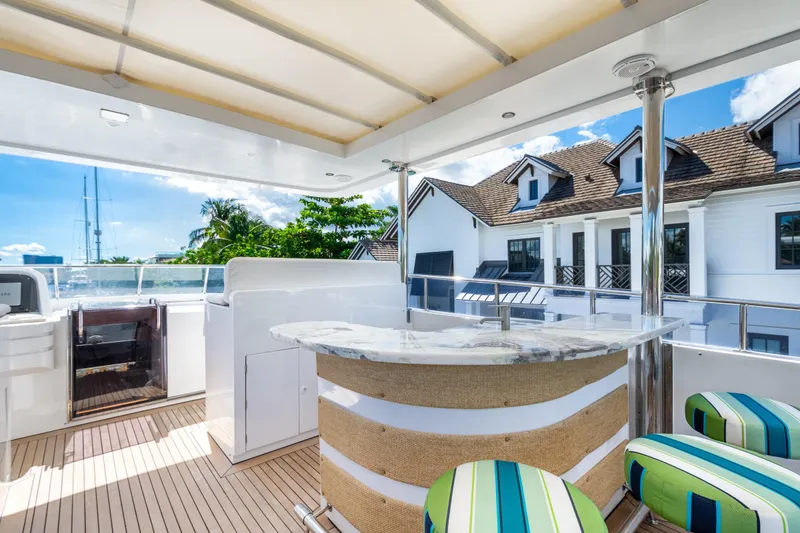 Slide: The Image of Luxurious 2006 Hargrave Raised Pilothouse yacht deck with bar and striped seating. - 14