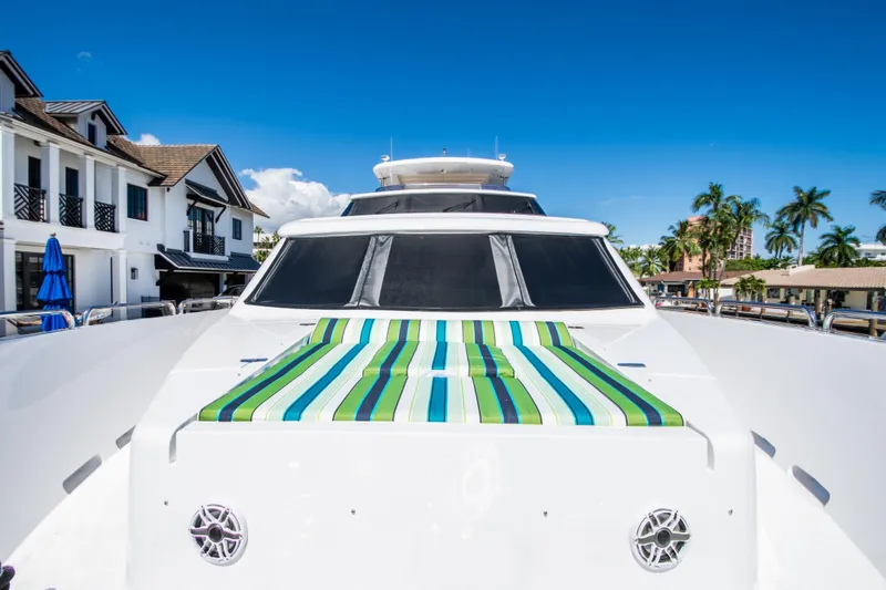 Slide: The Image of 2006 Hargrave Raised Pilothouse yacht with striped sunbed, docked near luxury homes and palm trees. - 17