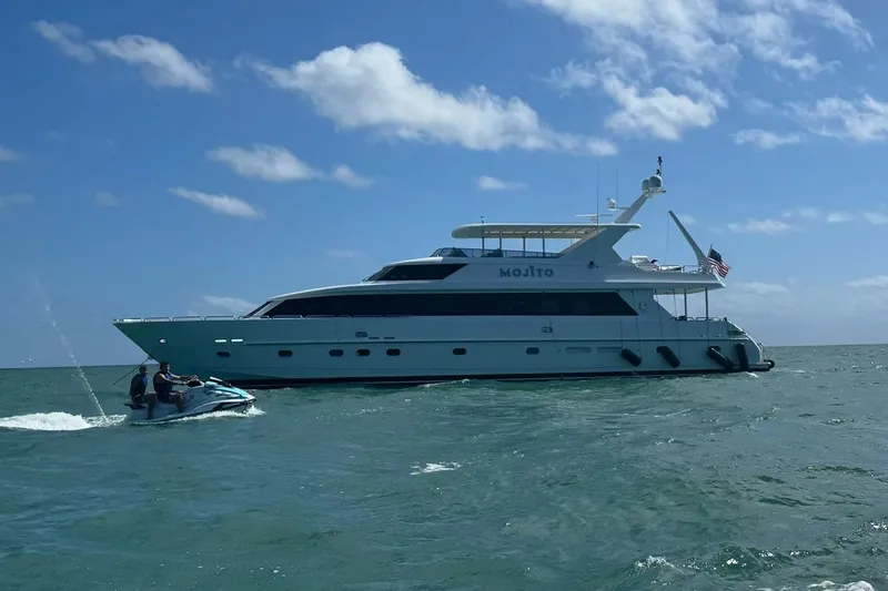 Slide: The Image of 2006 Hargrave Raised Pilothouse yacht with jet ski on ocean under blue sky. - 2