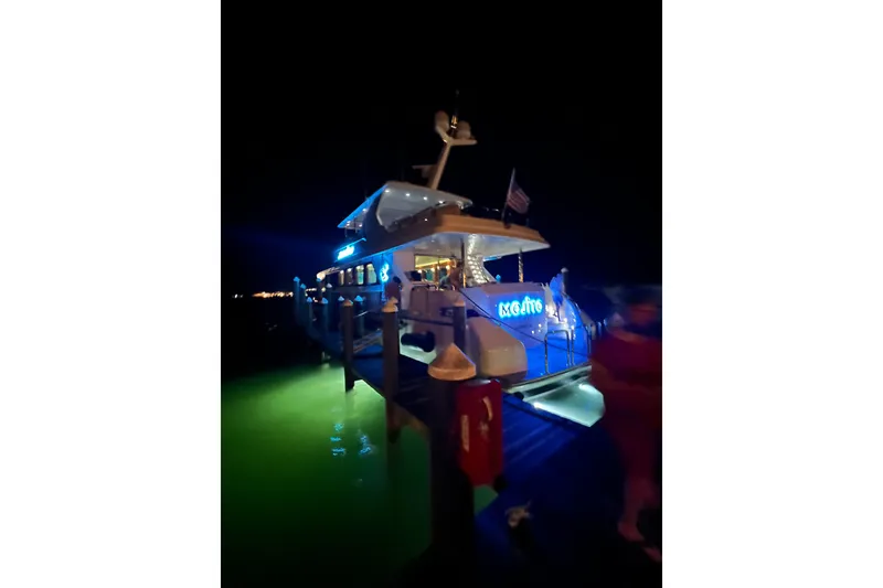 Slide: The Image of Luxury 2006 Hargrave Raised Pilothouse yacht docked at night with vibrant blue lighting. - 7