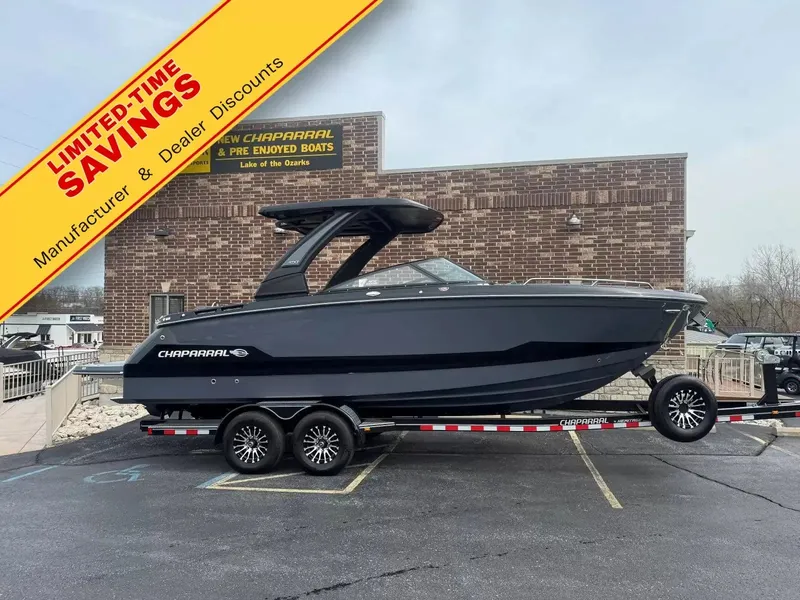 The Image of The image shows a black Chaparral 8 SSX boat on a trailer in front of a brick building. - 1