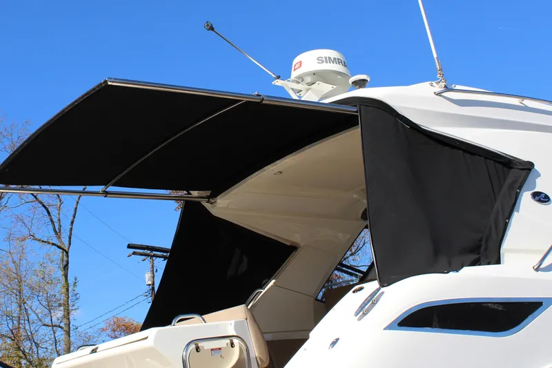 Slide: The Image of 2017 Sea Ray Sundancer 350 Coupe with extended sunshade under clear blue sky. - 27