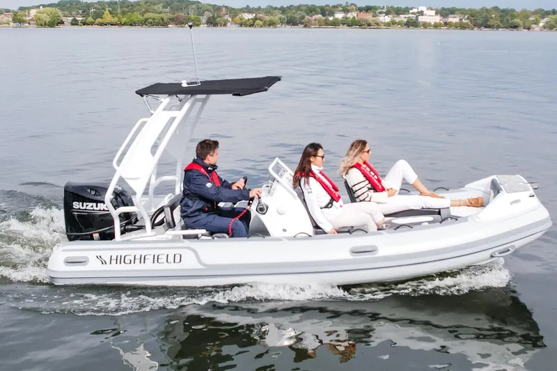 Slide: The Image of Highfield Sport 520 boat cruising on water, 2026 model, with canopy and seating. - 13