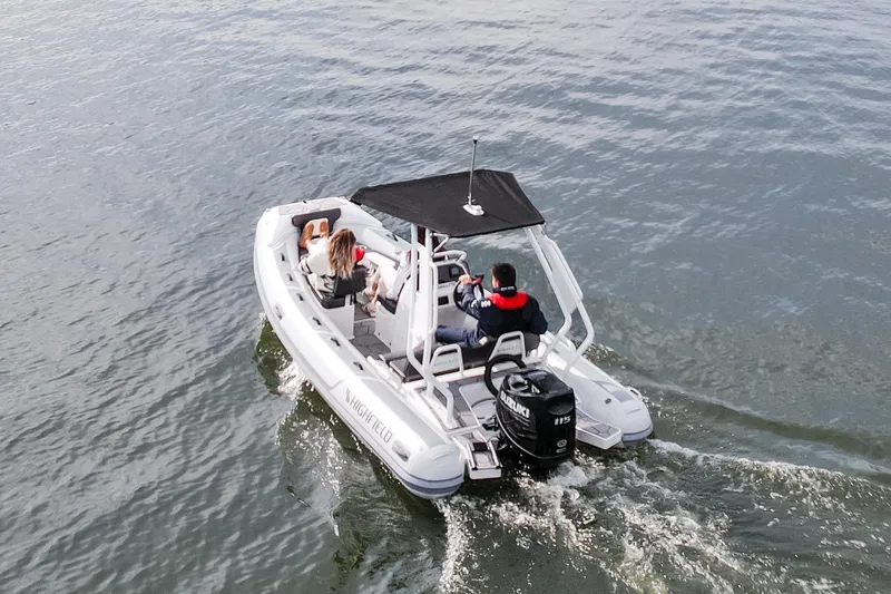 Slide: The Image of Highfield Sport 520 boat cruising on water, 2026 model, with passengers onboard. - 15