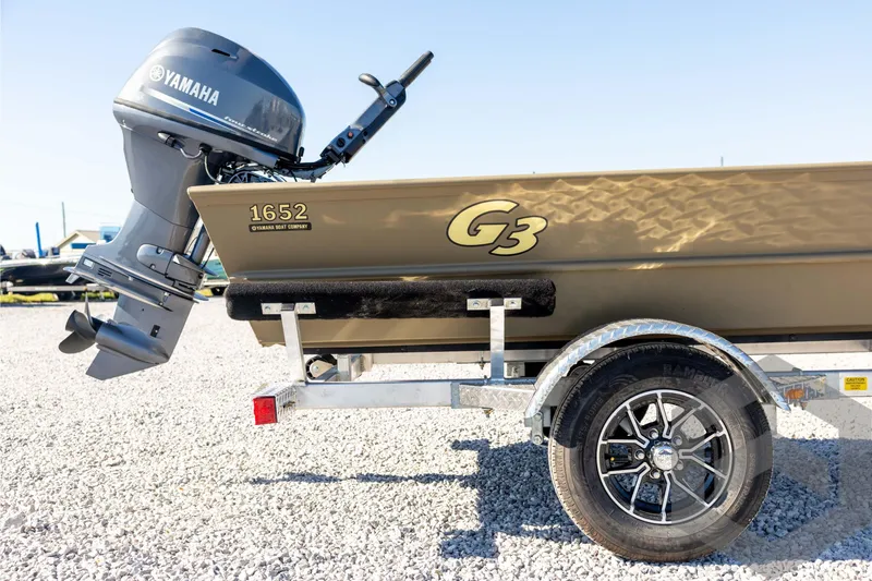 Slide: The Image of 2026 G3 1652 VBW boat with Yamaha motor on a trailer, parked on gravel. - 14