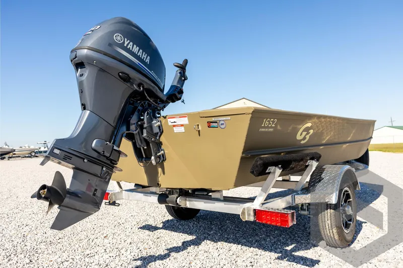 Slide: The Image of 2026 G3 1652 VBW boat with Yamaha outboard motor on trailer, parked on gravel. - 16