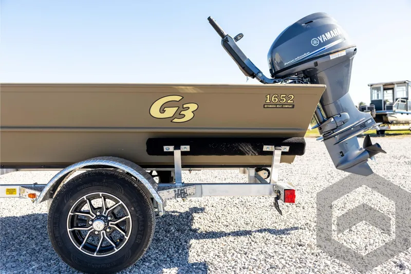 Slide: The Image of 2026 G3 1652 VBW boat with Yamaha motor on a trailer, parked on gravel. - 22