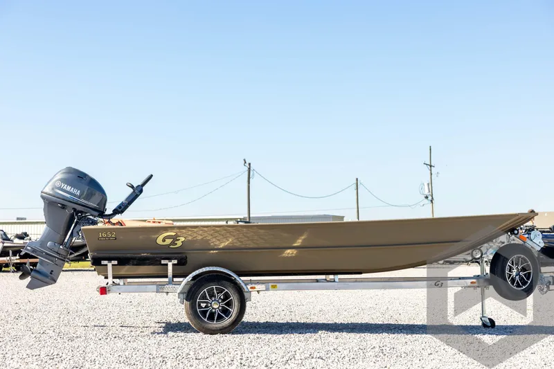 Slide: The Image of 2026 G3 1652 VBW boat with Yamaha motor on trailer, parked on gravel. - 4