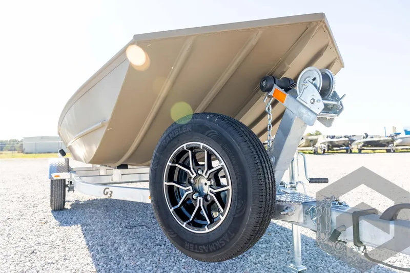 Slide: The Image of 2026 G3 1652 VBW boat on trailer with black wheel, parked on gravel. - 9