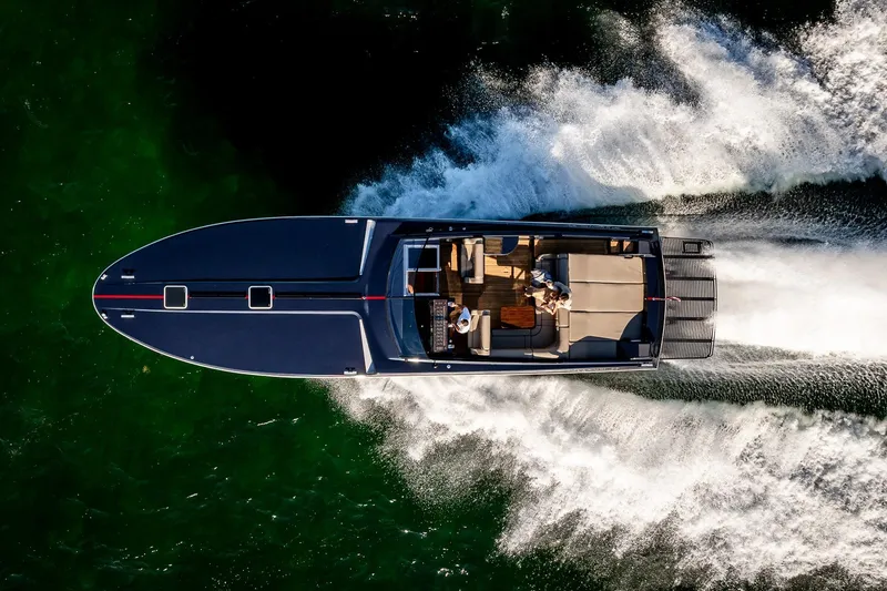 Slide: The Image of Aerial view of 2000 Magnum 50 Bestia yacht cruising on green water. - 21