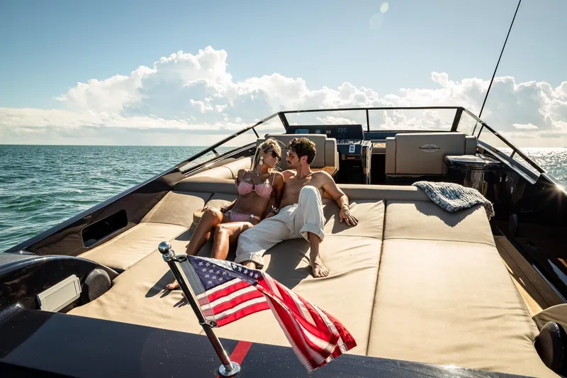 Slide: The Image of Couple relaxing on Magnum 50 Bestia yacht, 2000 model, with ocean view and American flag. - 37