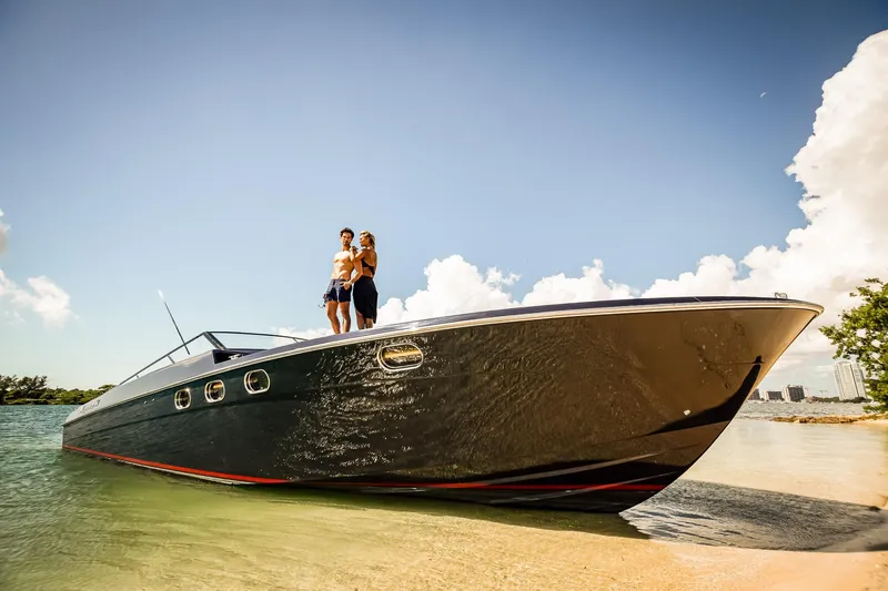 Slide: The Image of Couple on Magnum 50 Bestia yacht, 2000 model, anchored near sandy shore under clear sky. - 44