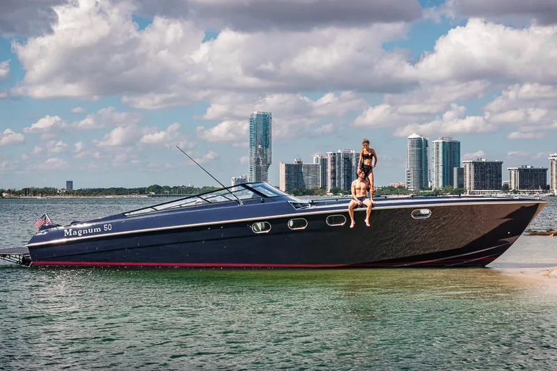 Slide: The Image of Luxury Magnum 50 Bestia yacht, 2000 model, with people onboard, city skyline in background. - 47