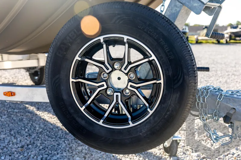 Slide: The Image of Trailer wheel of 2026 G3 1652 VBW on gravel, featuring black alloy rim. - 10