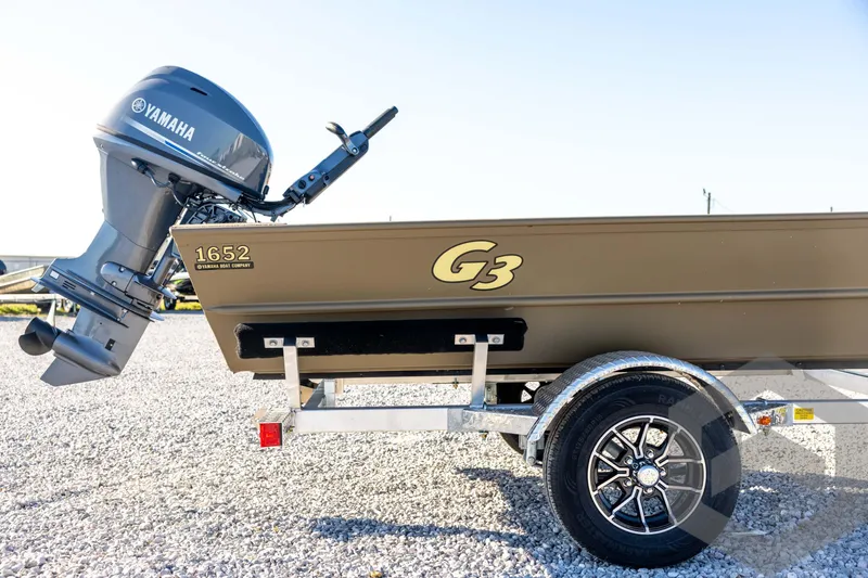 Slide: The Image of 2026 G3 1652 VBW boat with Yamaha motor on a trailer, parked on gravel. - 15