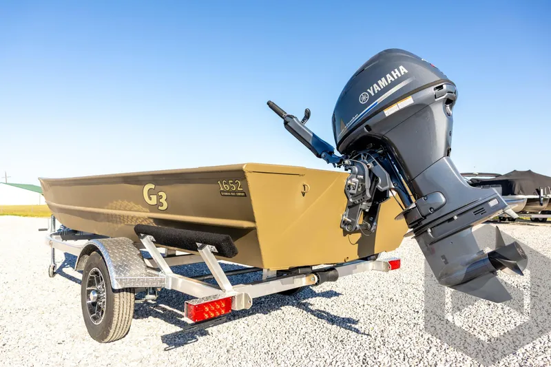Slide: The Image of 2026 G3 1652 VBW boat with Yamaha motor on trailer, parked on gravel. - 22