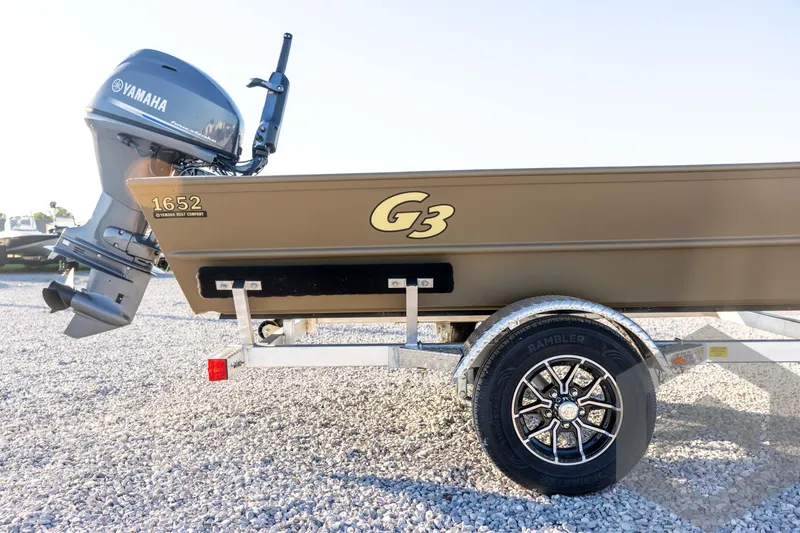 Slide: The Image of 2026 G3 1652 VBW boat with Yamaha motor on a trailer, parked on gravel. - 14