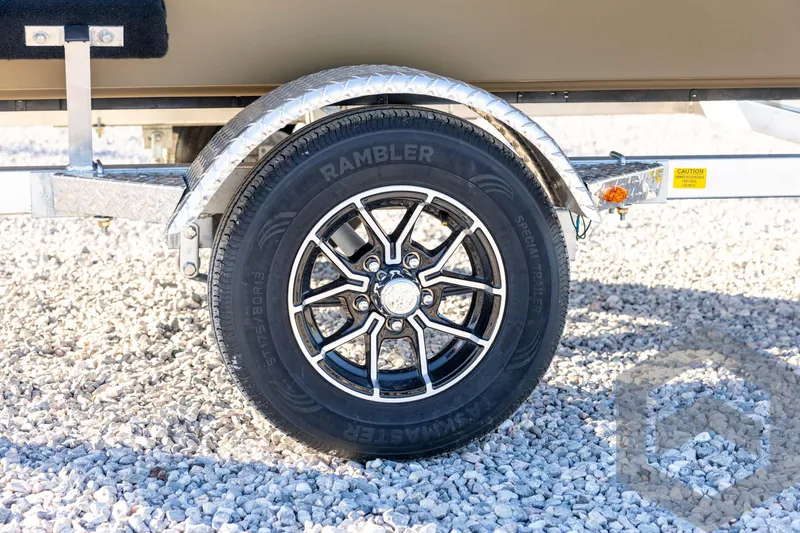 Slide: The Image of 2026 G3 1652 VBW trailer wheel on gravel, featuring Rambler tire and metal fender. - 15