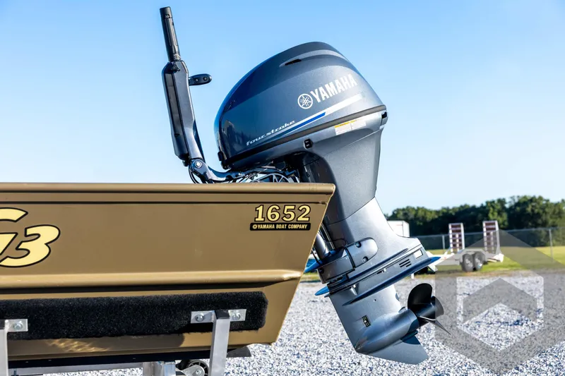 Slide: The Image of 2026 G3 1652 VBW boat with Yamaha outboard motor, parked on gravel. - 25