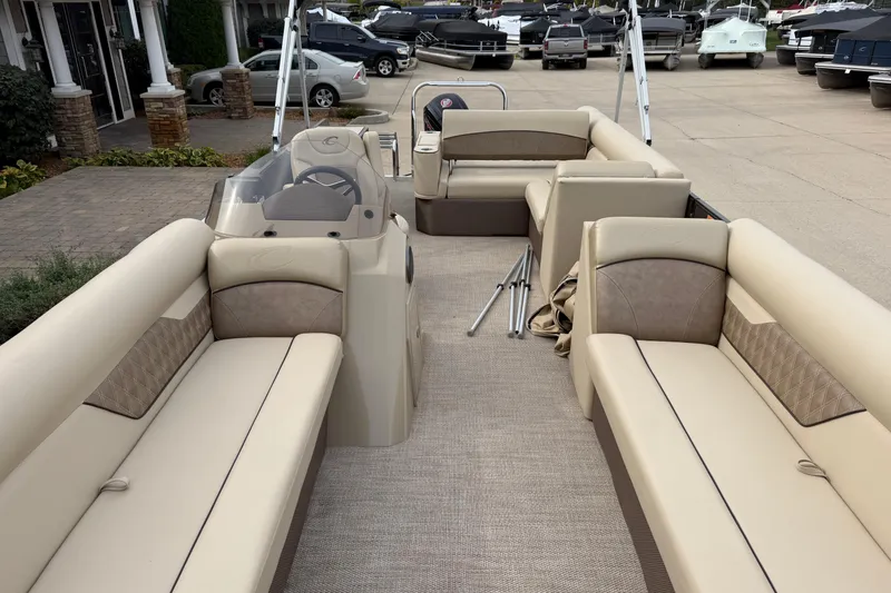 Slide: The Image of 2019 Crest II 240 SLS pontoon boat with cover in a storage facility. - 2