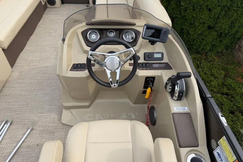 Slide: The Image of 2019 Crest II 240 SLS boat interior with beige captain's chair and control panel. - 8