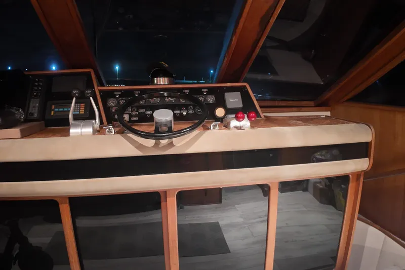 Slide: The Image of 1987 Viking Gulfstar yacht helm with steering wheel and control panel at night. - 15