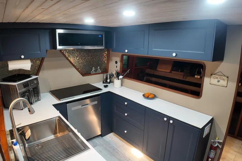 Slide: The Image of Modern kitchen interior of 1987 Viking Gulfstar yacht with blue cabinets and stainless steel appliances. - 28