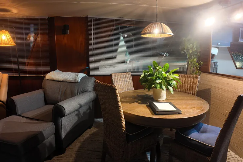 Slide: The Image of Cozy 1987 Viking Gulfstar yacht interior with armchair, round table, and potted plant. - 30
