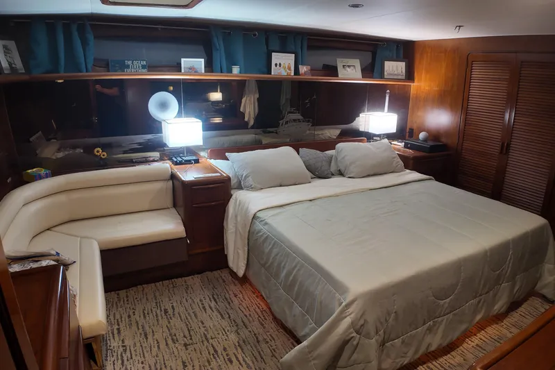 Slide: The Image of Luxurious 1987 Viking Gulfstar yacht bedroom with king-size bed, elegant decor, and ambient lighting. - 32