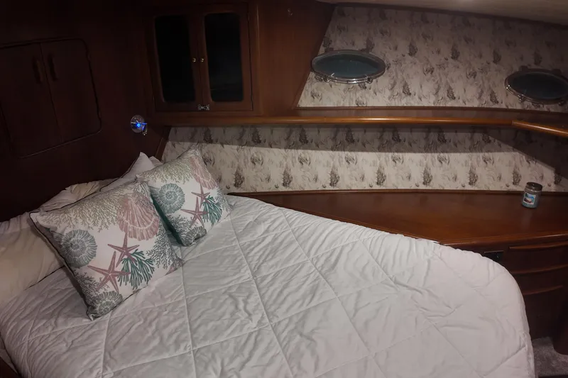 Slide: The Image of Cozy cabin interior of 1987 Viking Gulfstar with nautical-themed bedding and wooden accents. - 37