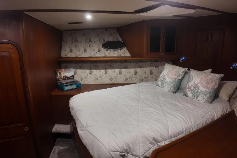 Slide: The Image of Cozy bedroom interior of 1987 Viking Gulfstar yacht with wood paneling and decorative pillows. - 38