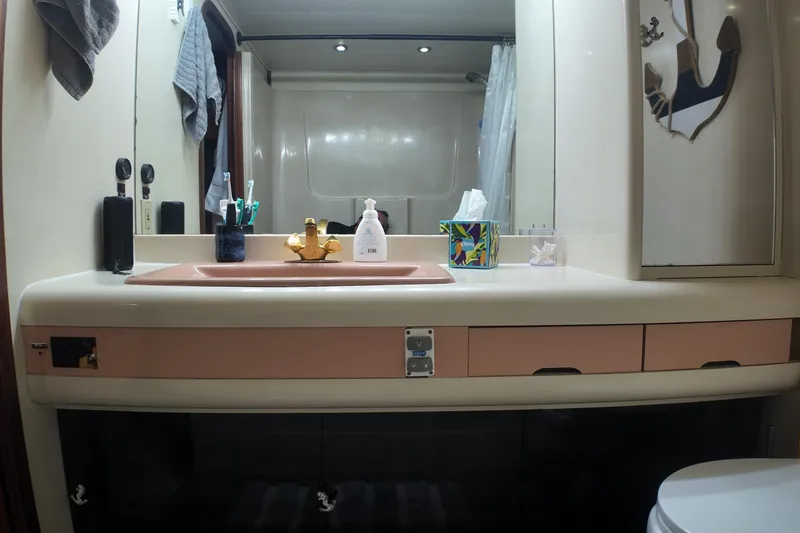 Slide: The Image of Bathroom interior of 1987 Viking Gulfstar yacht with sink, mirror, and toiletries. - 41
